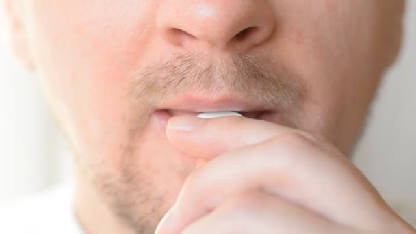 Extreme closeup man face taking white pill — Stock Video