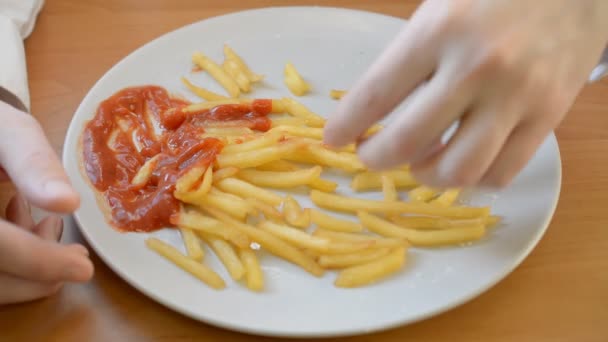 Mãos compartilhando deliciosas batatas fritas final de almoço servido em um prato grande com ketchup — Vídeo de Stock