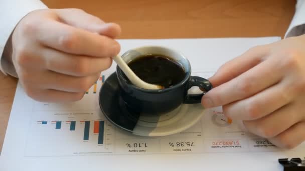 Biznesmen ingeruje z cukrem w filiżankę kawy na pulpicie — Wideo stockowe