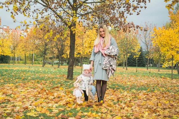 Happy mother and little daughter at autumn park