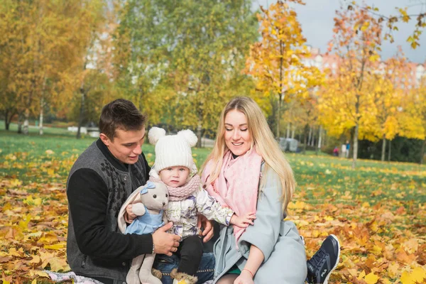 Young happy family in the autumn park — Stockfoto