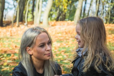 Genç anne parkta sevimli bebeğiyle oynuyor.