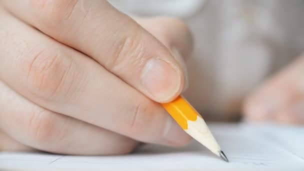 Mans mano hace una nota de negocios en un cuaderno con un lápiz — Vídeos de Stock