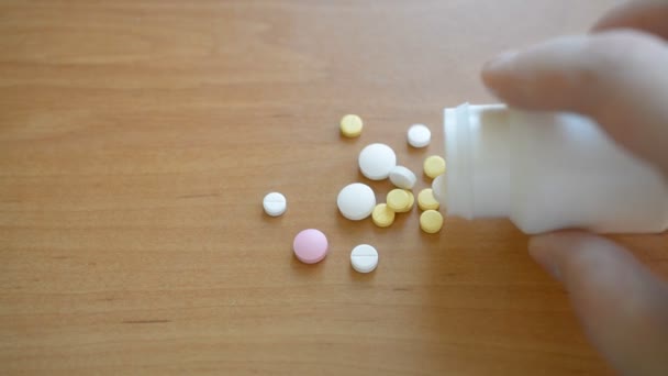 Hand giet uit pillen uit de fles op de tafel — Stockvideo