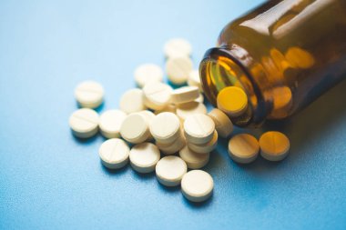 Mavi arka planda soğuk algınlığı veya grip tedavisi için sarı haplar