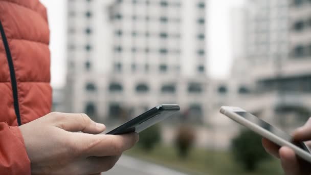 Teenager hands using smartphone over modern buildings — Stock Video