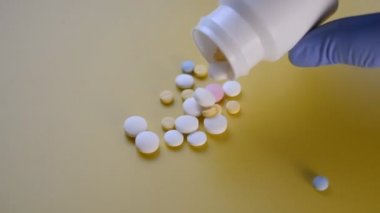 painkiller pills falling on a yellow background