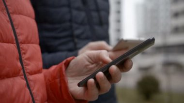 Fingers of a young couple using on a smartphone device
