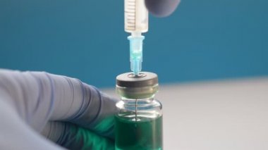 Doktor koronovirüs ya da grip virüsü için bir enjeksiyon hazırlar.