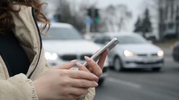 Дівчина використовує карту в смартфоні, щоб знайти шлях у місті — стокове відео
