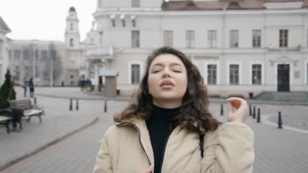 Beautiful brunette girl walks along the street of her city — Wideo stockowe