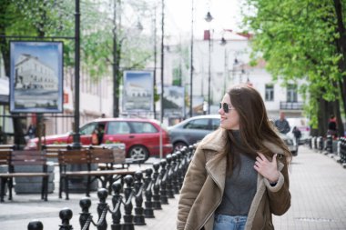 Güzel kız baharda cadde boyunca yürür