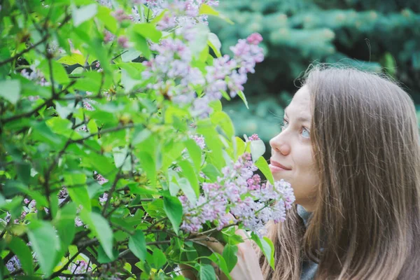 Menina posando perto de arbustos lilás — Fotografia de Stock