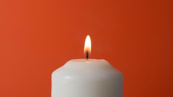 Белое пламя свечи на красном фоне — стоковое видео