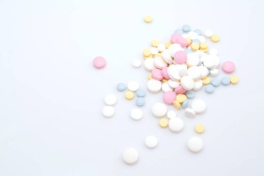 İlaç konseptiyle koronavirüs tedavisi, beyaz arka planda renkli hapların kaydırılması