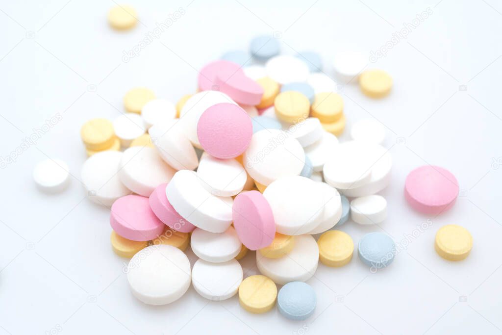 coronavirus treatment with pills concept, slide of colored pills on white background
