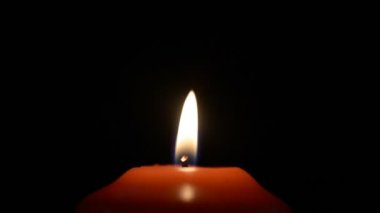 Rüzgarın estiği karanlıkta kırmızı mum alevinin hareketi