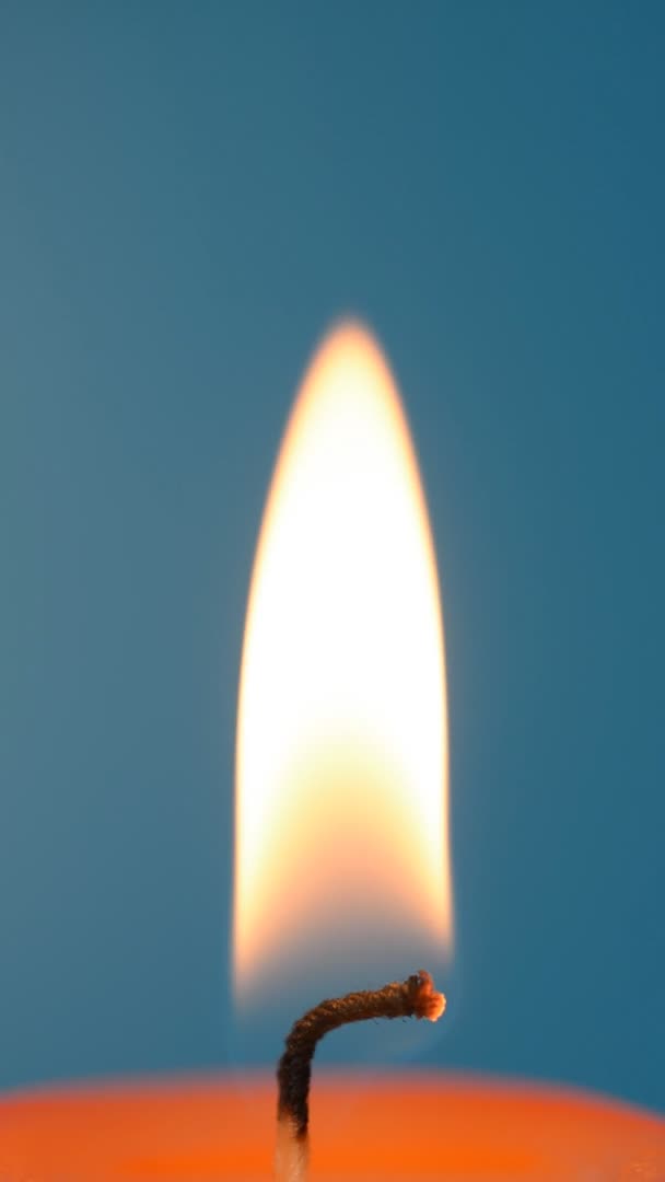 Kerzenflamme auf blauem Hintergrund — Stockvideo