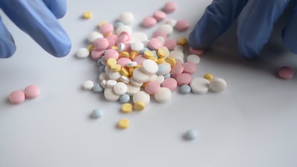 Les mains du médecin choisit des pilules colorées de comprimé de médicaments colorés poignée 