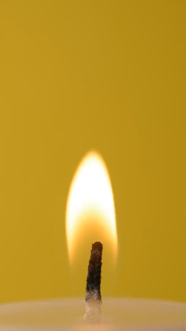 Close-up candle fire on a yellow background — Stock Video