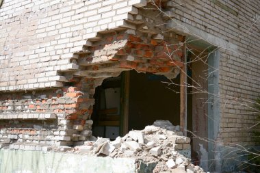 Ormanda terk edilmiş tuğla bir binanın yıkılmış duvarı.