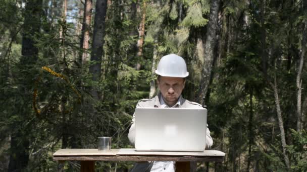 Σύγχρονος δασονόμος εργάζεται στο δάσος σε ένα φορητό υπολογιστή — Αρχείο Βίντεο