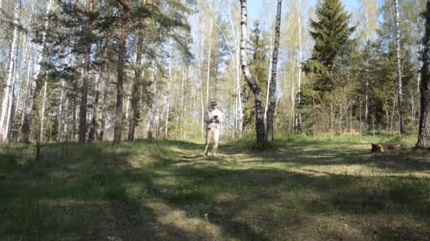 Un forestale con una tavoletta esamina la foresta e prende appunti — Video Stock