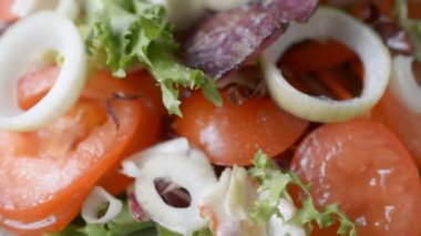 Taze marul ve domatesli vejetaryen salatası arka planda döner