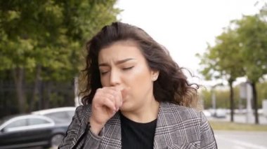 Dışarıda öksüren genç bir kızın portresi.