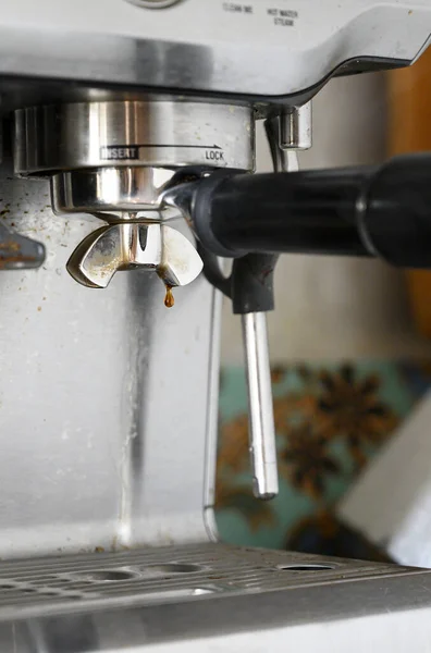 The horn often used coffee machine whose horn is located in the working slot of the coffee machine. A drop of freshly brewed coffee hangs from the horn.
