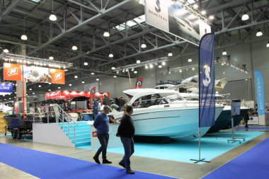 Moscow / Russia  03 05 2020: Beneteau motor boats wiyh people visitors on 13th International Moscow Boat Show 2020 in Crocus Expo exhibition center clipart
