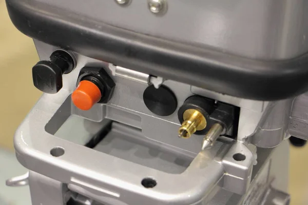 Portable boat outboard motor control pznel close up - handle, STOP button, choke knob and fuel connector