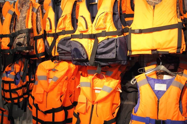 A lot bright marine life jackets close up in shop, safety on water tourism activity and watersports