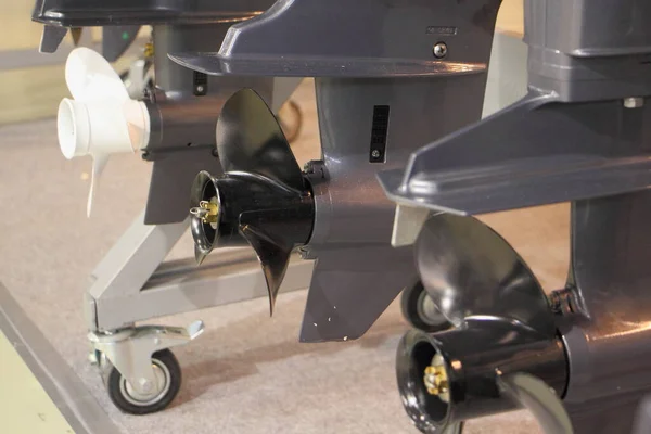 Outboard motors gears with boat propellers on stand in perspective, outboards service repair