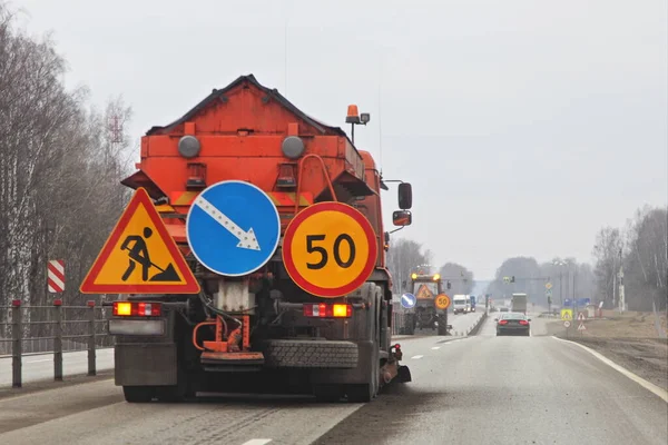 ロシアオレンジ色のアスファルトスイーパートラックは 春の道路をきれいに車線を残し 自治体高速道路清掃サービス — ストック写真