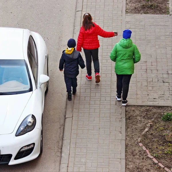 儿童步行在人行道上 靠近停放的白色汽车 儿童的行人在公路交通中的安全 — 图库照片