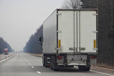 Bahar günü boş iki şeritli yolda çağdaş beyaz kamyonet, uluslararası kargo lojistik malları teslimatı.