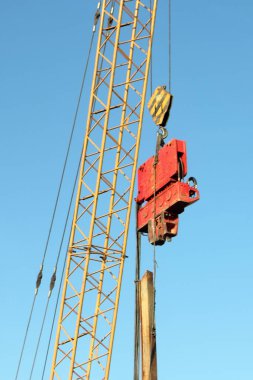 Bir vincin taşıması ve patlaması mavi gökyüzüne yakın, inşaat makineleri