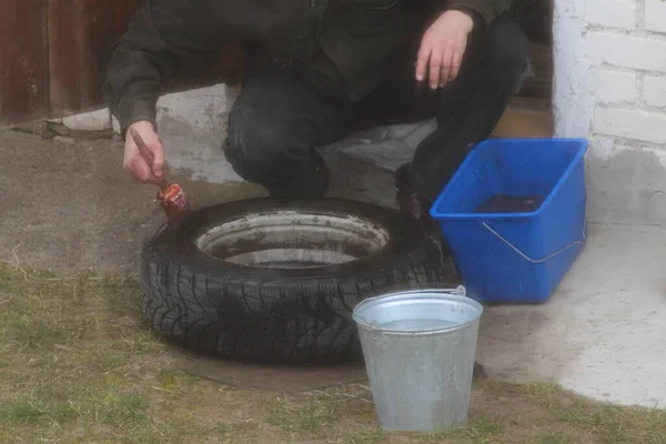 Ein Mann Sucht Eine Reifenpanne Einem Autorad Mit Wasser Und — Stockfoto
