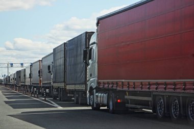 Large endless queue of trucks with semi trailers to the control point in the spring against the blue sky, clipart