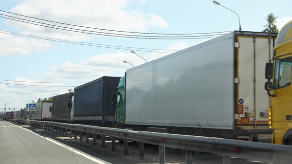 Long queue traffic congestion of many heavy trucks with semi-trailers to the control point in perspective, EAC sanctions