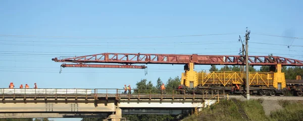 Russian rail loader crane on a railway bridge, replacement of rails, repair of the trackbed