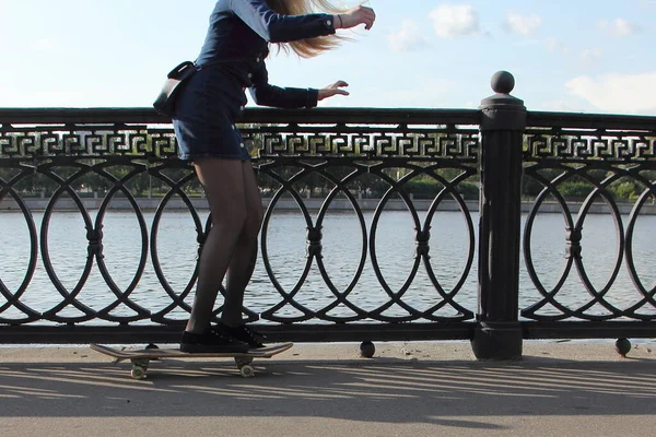 Uma Jovem Caucasiana Vestido Curto Escuro Aprende Andar Skate Perto — Fotografia de Stock