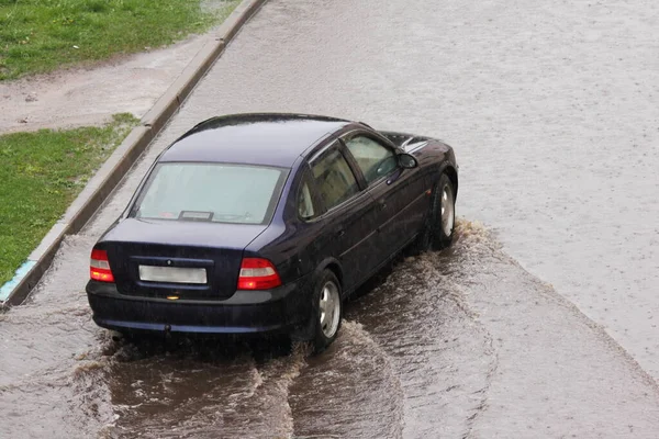 Dark Car Slow Drives Large Puddle Background Curb Green Grass — Stock Photo, Image