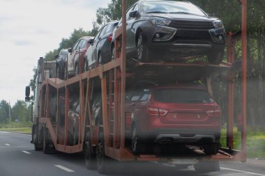 İki katlı taşıma kamyonu, iki eksenli karavan, banliyö otoyolu, arka taraf görüntüsü, teslimat otomobil lojistiği, otomobil ulaşımı.