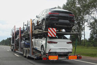 İki katlı taşıma kamyonu, iki eksenli karavan ile banliyö otobanında, yan dikiz penceresi yakın, teslimat otomobili lojistiği, otomobil ulaşımı.