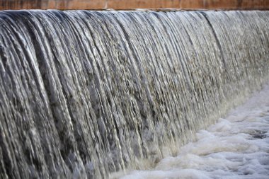 Şehir nehri şelalesi. Büyük çağlayan duvar. Bir yaz günü yakın çekim.