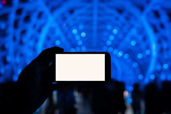 Renkli arkaplanı olan akıllı bir telefon tutan adam