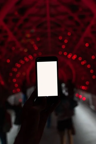 Renkli arkaplanı olan akıllı bir telefon tutan adam