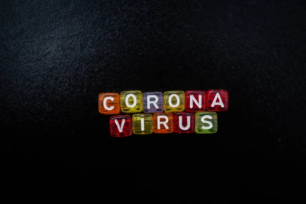 Siyah arkaplan üzerine renkli kelime CORONA VIRUS İngiliz alfabe küpü, seçici odak